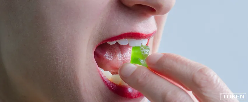 THC - Woman eating green gummy bear